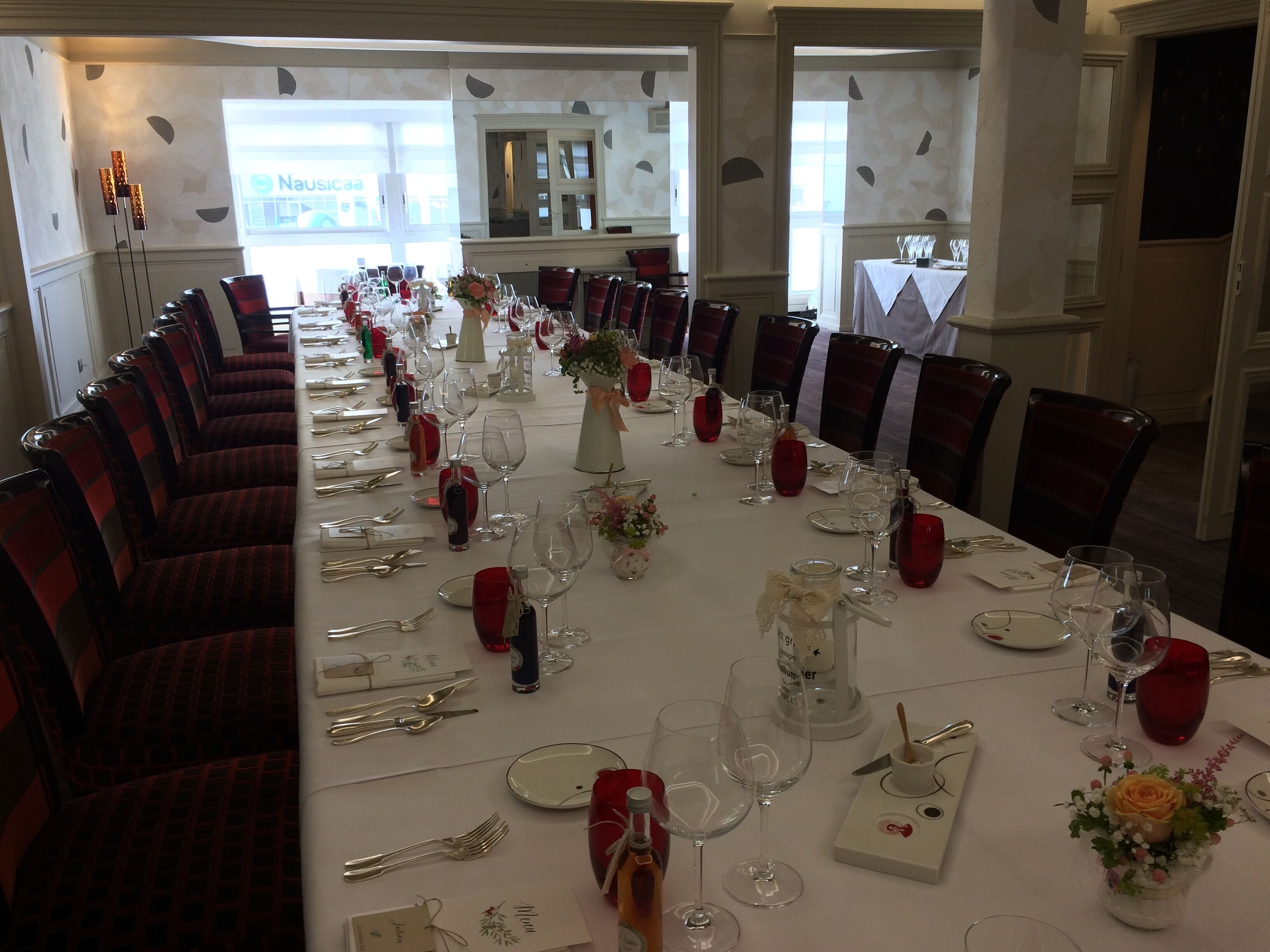 A long dining table set for a formal event, with chairs on both sides.