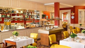 Un restaurant doté d’un bar, de tables dressées pour le service, et où une variété d’ustensiles de cuisine sont exposés sur des étagères.