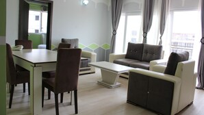 Una sala de estar moderna con una mesa de comedor, sillas, un sofá y una mesa de centro.