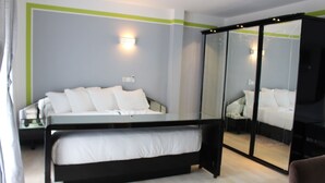 Un dormitorio moderno con cama, mesita de noche y mueble con espejo.