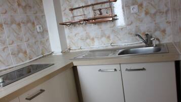 A kitchen with a sink, countertop, and cabinets.