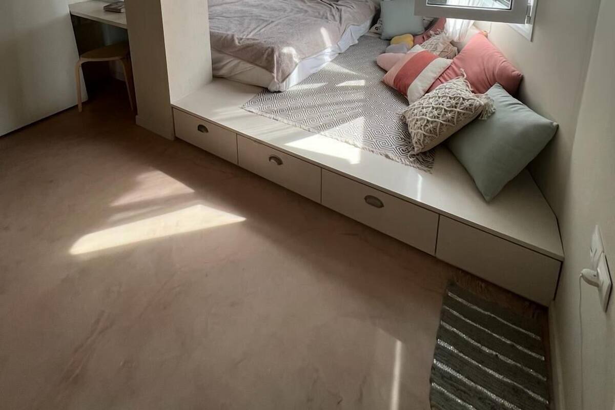 A bedroom with a built-in bed, a desk, and a mirror.