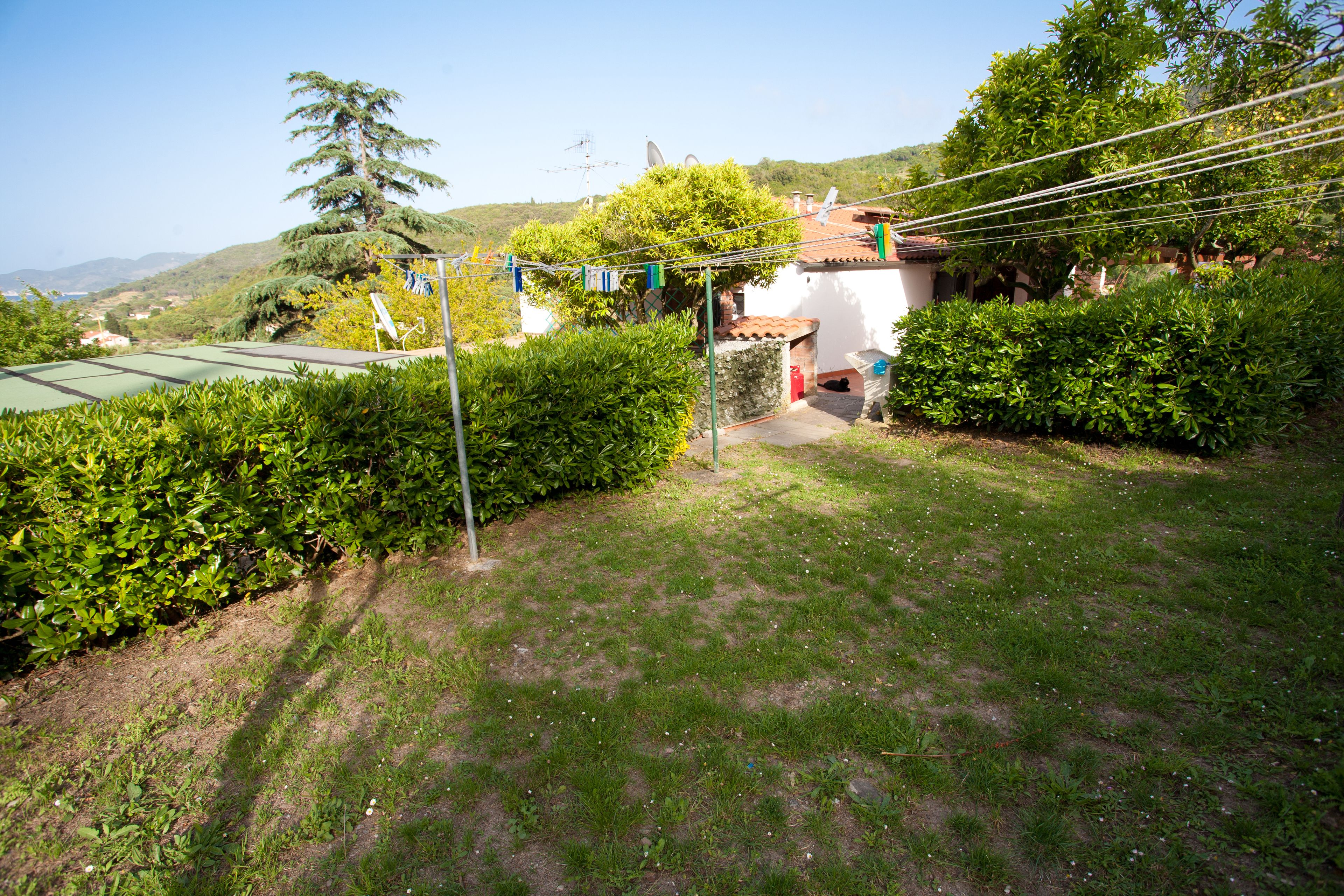 A residential property with a well-maintained lawn, a satellite dish, and a small garden area.