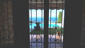 Une vue à travers une grille en métal, avec une piscine et un ciel dégag é.