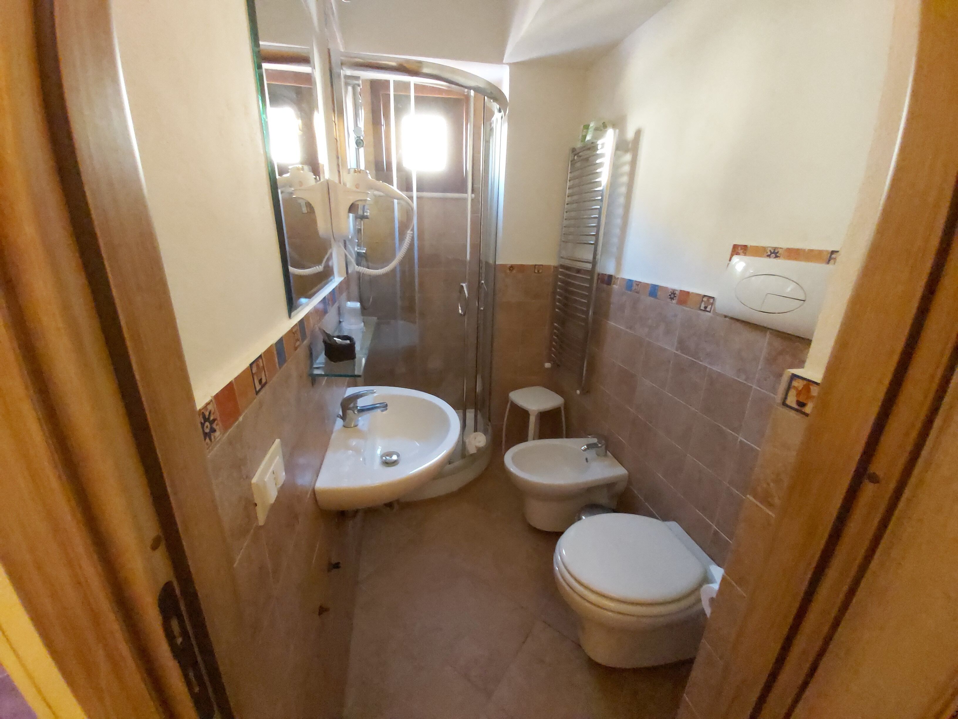Ein kleines Badezimmer mit Waschbecken, Toilette und Dusche.