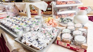 A buffet with various food items including yogurt, eggs, and pastries.