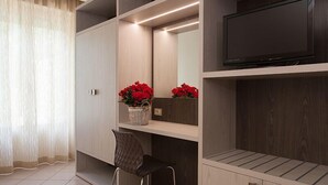 A modern room with built-in shelving, a flat-screen TV, and a chair.