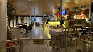 Un bar sportif intérieur avec des tables et des chaises, un comptoir et un plafond en bois.