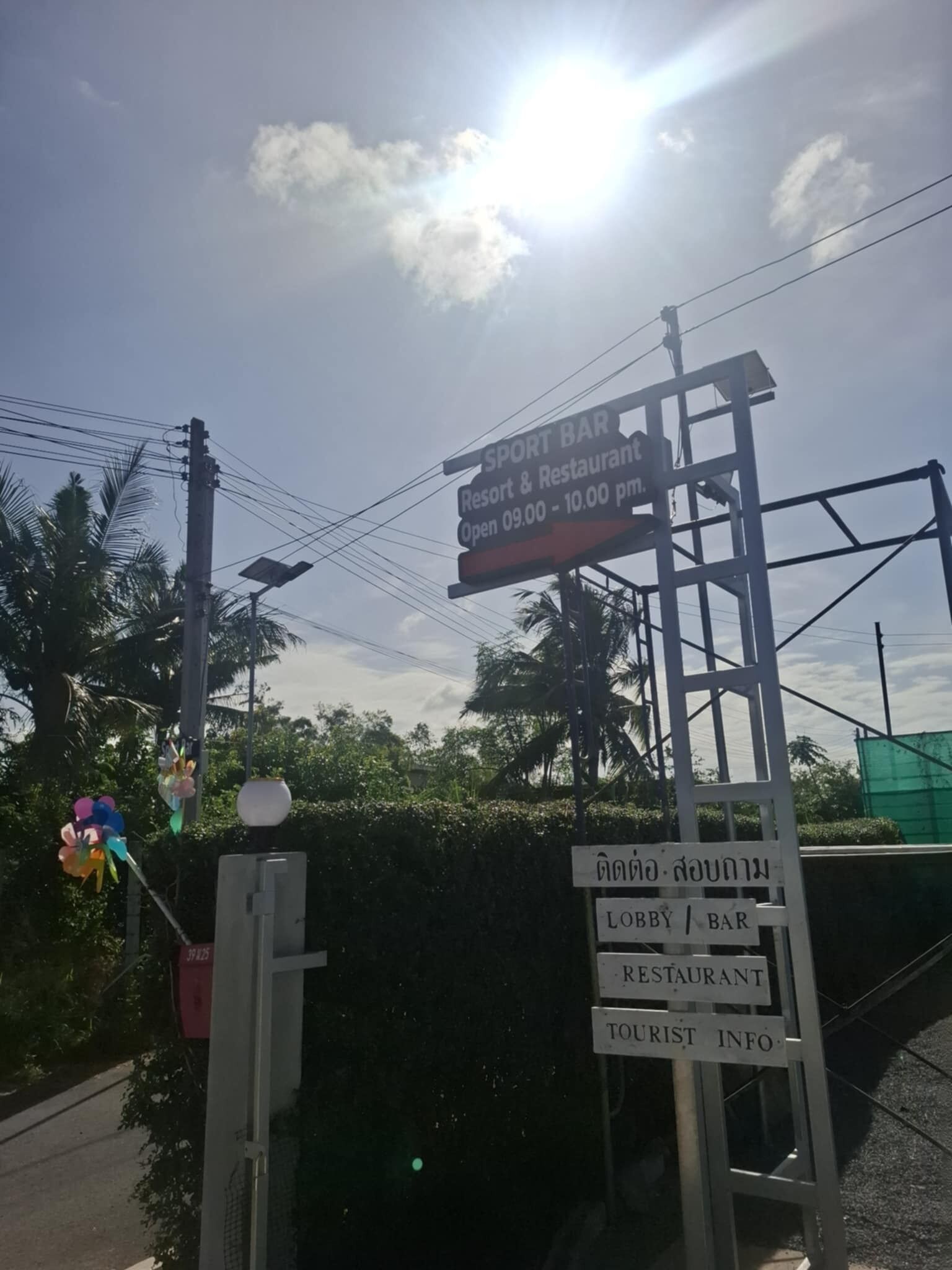 A signboard for a Sport Bar Resort & Restaurant, open from 09:00 to 10:00 pm.