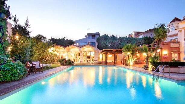 A swimming pool with a clear view of the surrounding buildings and greenery. - Oasis Pool House by GHH (Saronikos)