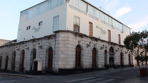 A historic building with large windows and a stone facade. - Hotel Tikary (Arequipa)