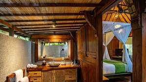 Un baño de madera con un lavamanos grande, un espejo y armarios de madera.
