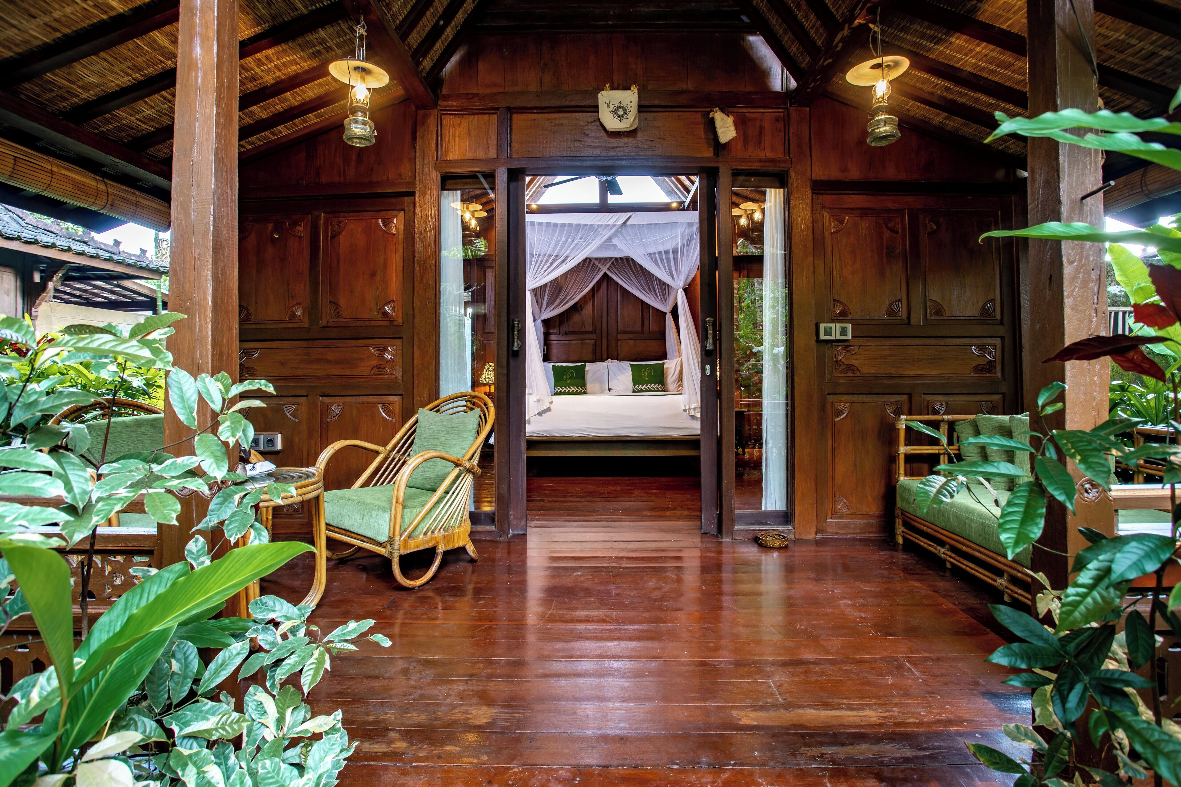 A wooden room with a bed, a chair, and a table.