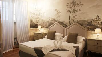 A hotel room with a large bed, two bedside tables, a nightstand, a lamp, and a mural on the wall.