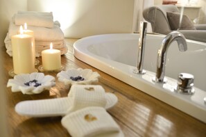 A bathroom with a white sink, a mirror, and a towel rack. There are candles and decorative items on the counter.