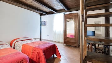 Ein Schlafzimmer mit zwei Betten, einem Holzschrank und einem Fernseher.