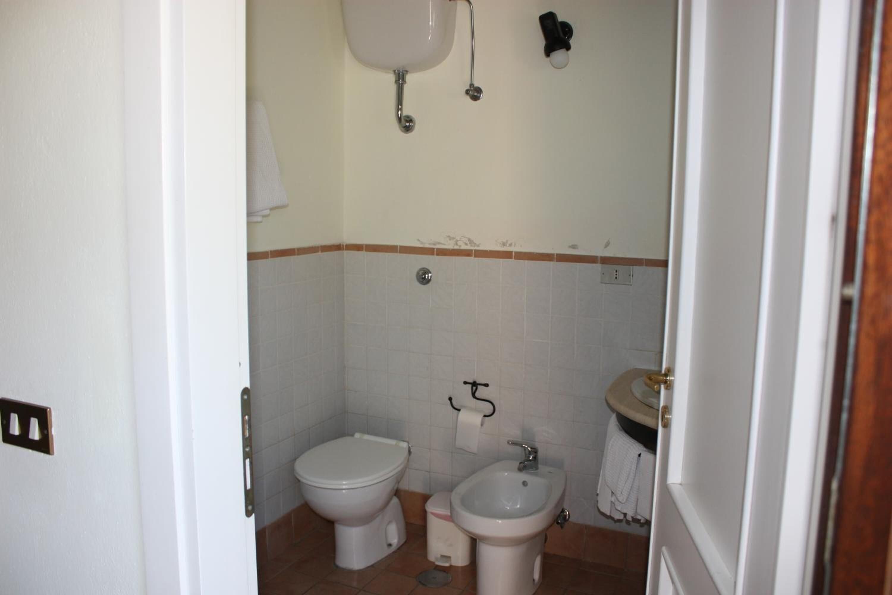 A small bathroom with a toilet, bidet, and sink.