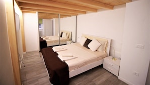 A bedroom with a bed, bedside tables, a mirror, and a wooden ceiling. - Budapest Easy Flat - Teresa Lux Apartment (Budapest)