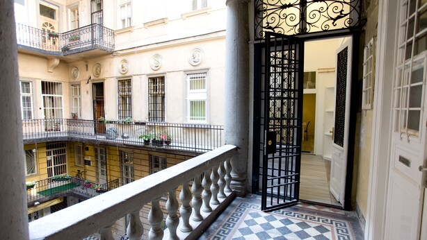 A multi-level building with balconies, a checkered floor, and a decorative wrought iron gate. - Budapest Easy Flat - Teresa Lux Apartment (Budapest)