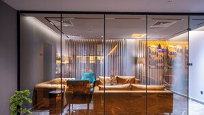 Um interior moderno com um sofá modular, uma poltrona azul e uma pequena mesa.