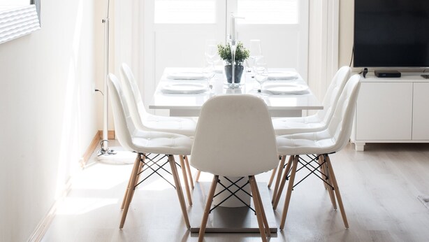A dining area with a table set for four, a modern floor lamp, and a television on a cabinet. - Budapest Easy Flat - Basilica Lux (Budapest)