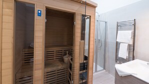 A modern bathroom with a wooden sauna, a glass shower enclosure, and a white sink. - Budapest Easy Flat - Basilica Lux (Budapest)
