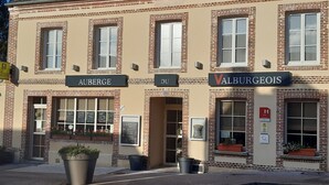 Un bâtiment sur lequel on peut voir trois enseignes : « AUBERGE », « DU » et « VALBURGEOI ».
