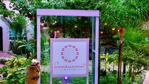A sign for 'Santuario Playa' with a water feature and lush greenery in the background. - Santuario Playa (Playa del Carmen)