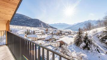 A snowy mountain village with a wooden balcony overlooking the valley.