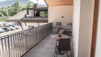 Ein Balkon mit Blick auf geparkte Autos und Berge.
