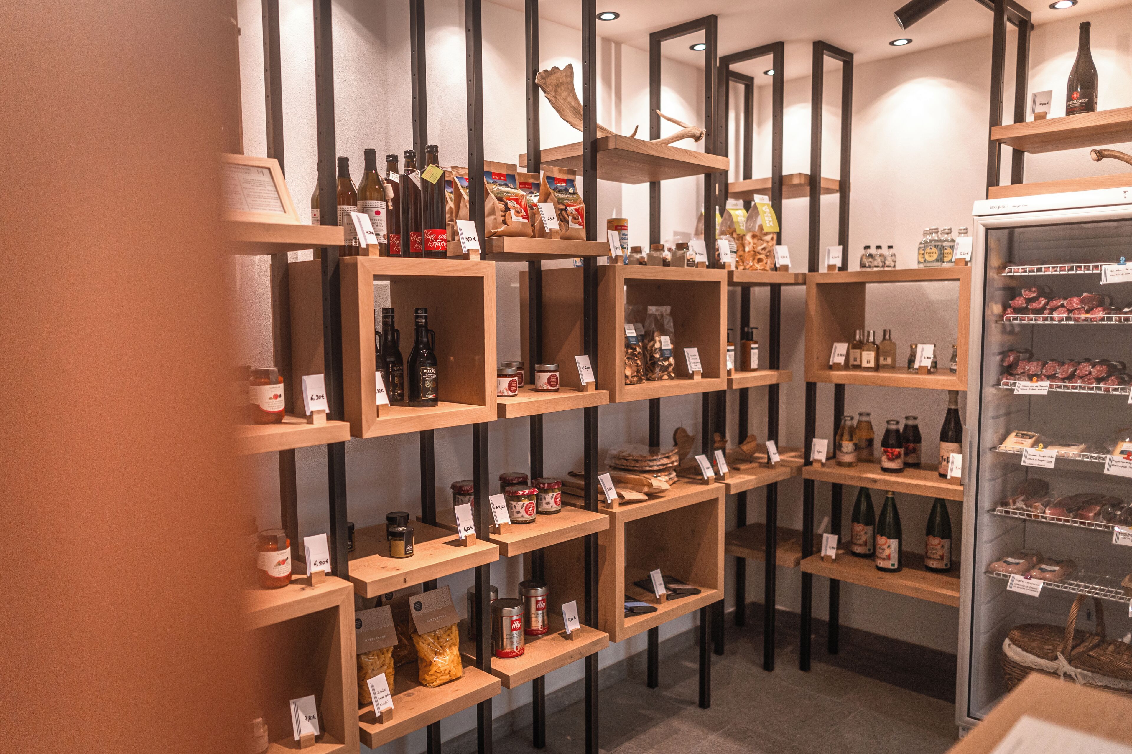 A wine and spirits store with wooden shelves and a refrigerated display case.