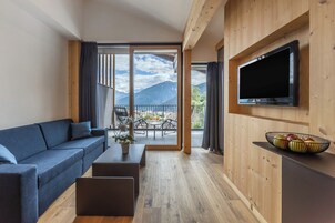 Una sala de estar moderna con un sofá, una mesa de centro y un televisor de pantalla plana montado en una pared de madera.