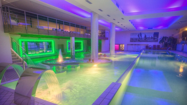 Una piscina con una fuente de agua y una escalera que sube a un nivel superior.