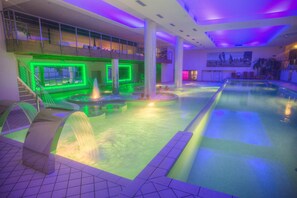A swimming pool with a water feature and a staircase leading to an upper level.