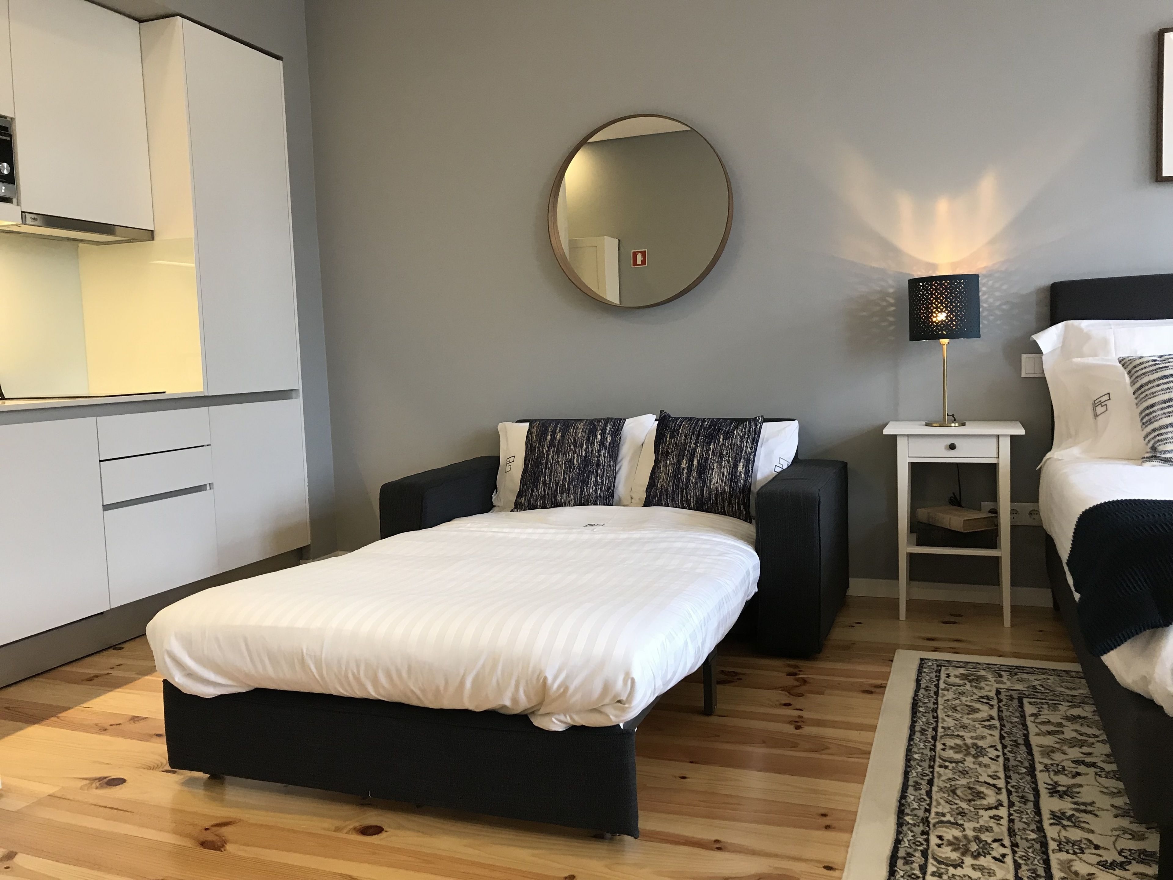 Ein modernes Schlafzimmer mit einem Bett, Nachttischen, einem Spiegel und einem Beistelltisch.
