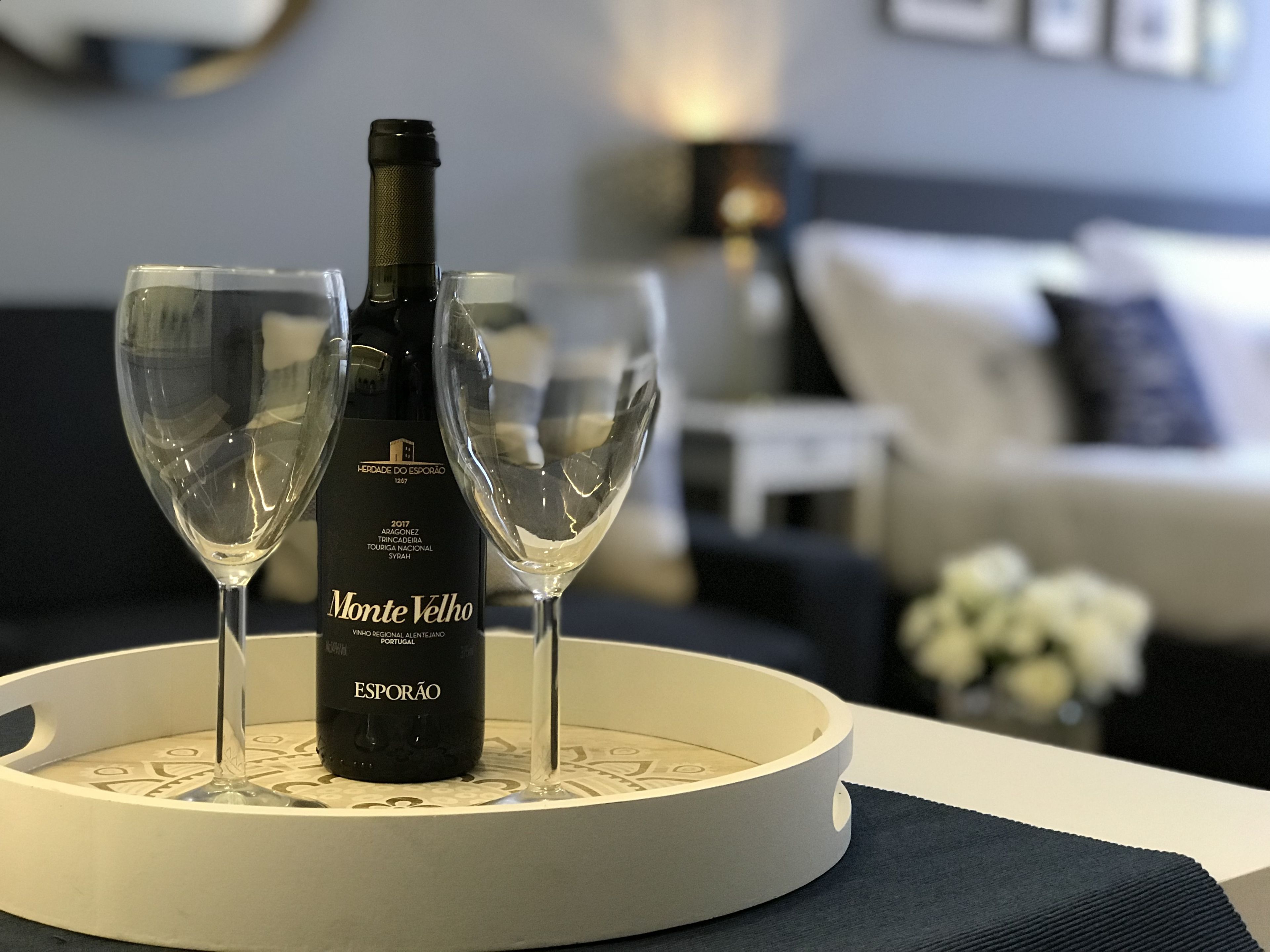 A bottle of Monte Vello wine on a tray with two glasses.