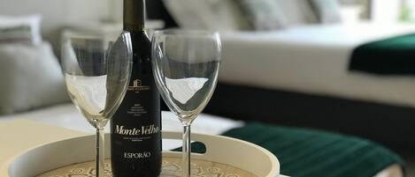 A bottle of Monte Vello wine and two wine glasses on a decorative tray in a hotel room.