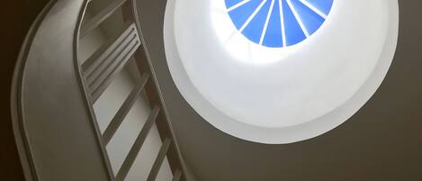 A spiral staircase with a circular skylight.