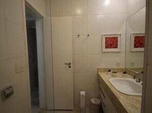 A bathroom with a white sink, a mirror, and a toilet. - GoHouse Parreiras 201 (Rio de Janeiro)