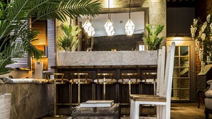 A modern interior with a marble counter, hanging lights, and seating. - The Cow Hollow Hotel (Manchester)
