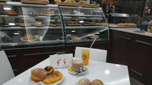 Une table avec des pâtisseries, une boisson et un menu, le tout dans un café.