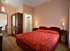 Cozy retreat with a large bed and two bedside tables, featuring a stylish headboard and a mirror.