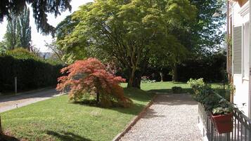 A pathway leading to a building with a well-maintained lawn and trees.