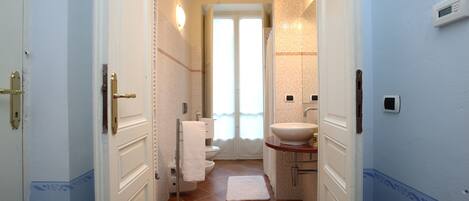Baño con lavamanos blanco, inodoro y ducha.