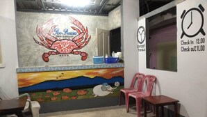 A restaurant interior with a mural, a clock, and seating. - Poopreaw Resort (Koh Lan)