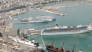 A large cruise ship docked at a port with a marina, a bridge, and a cityscape in the background. - Villa Aurora B&B (Bari)