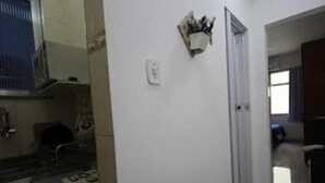 Cocina con estufa, fregadero y armarios. Hay una puerta que da a otra habitación.
