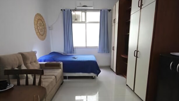 Una habitación con cama, sofá, mesa de comedor y armario.