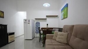Un espacio habitable compacto con kitchenette, comedor y sofá.
