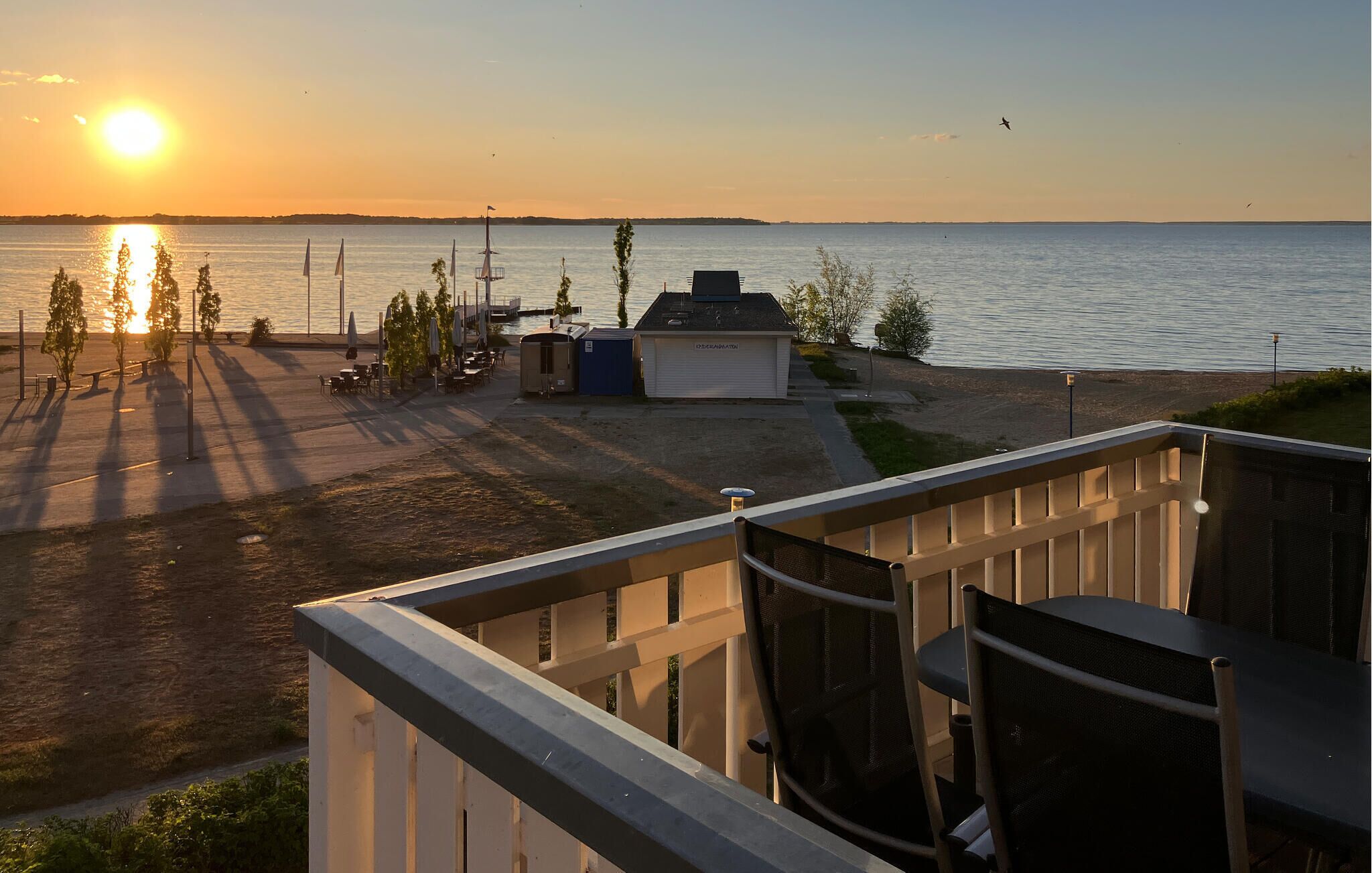 A waterfront view with a patio area, a small shed, and a boat dock.